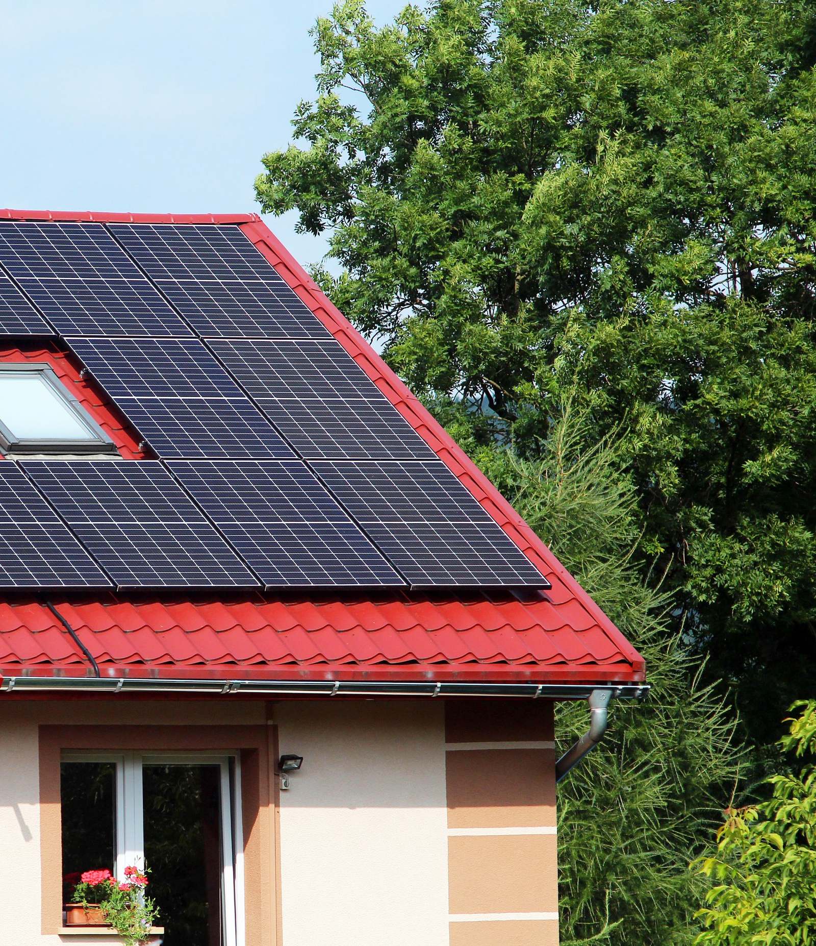 Vrijstaand huis met zonnepanelen op het dak in een groene omgeving