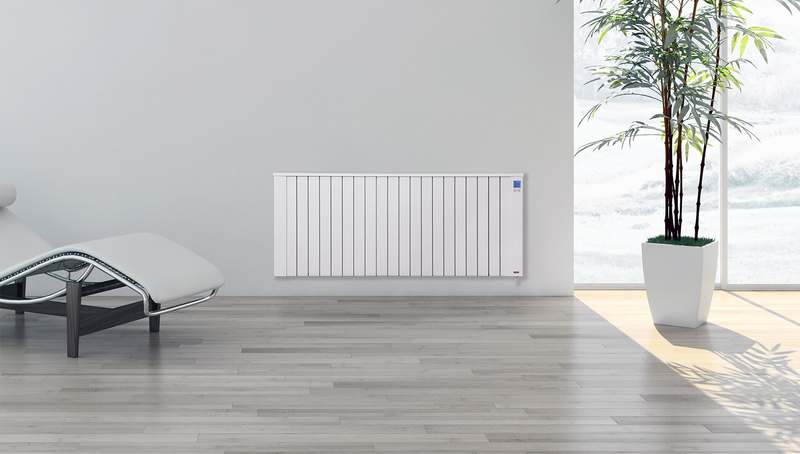 Witte Jawotherm radiator aan de wand in een woonkamer met een plant